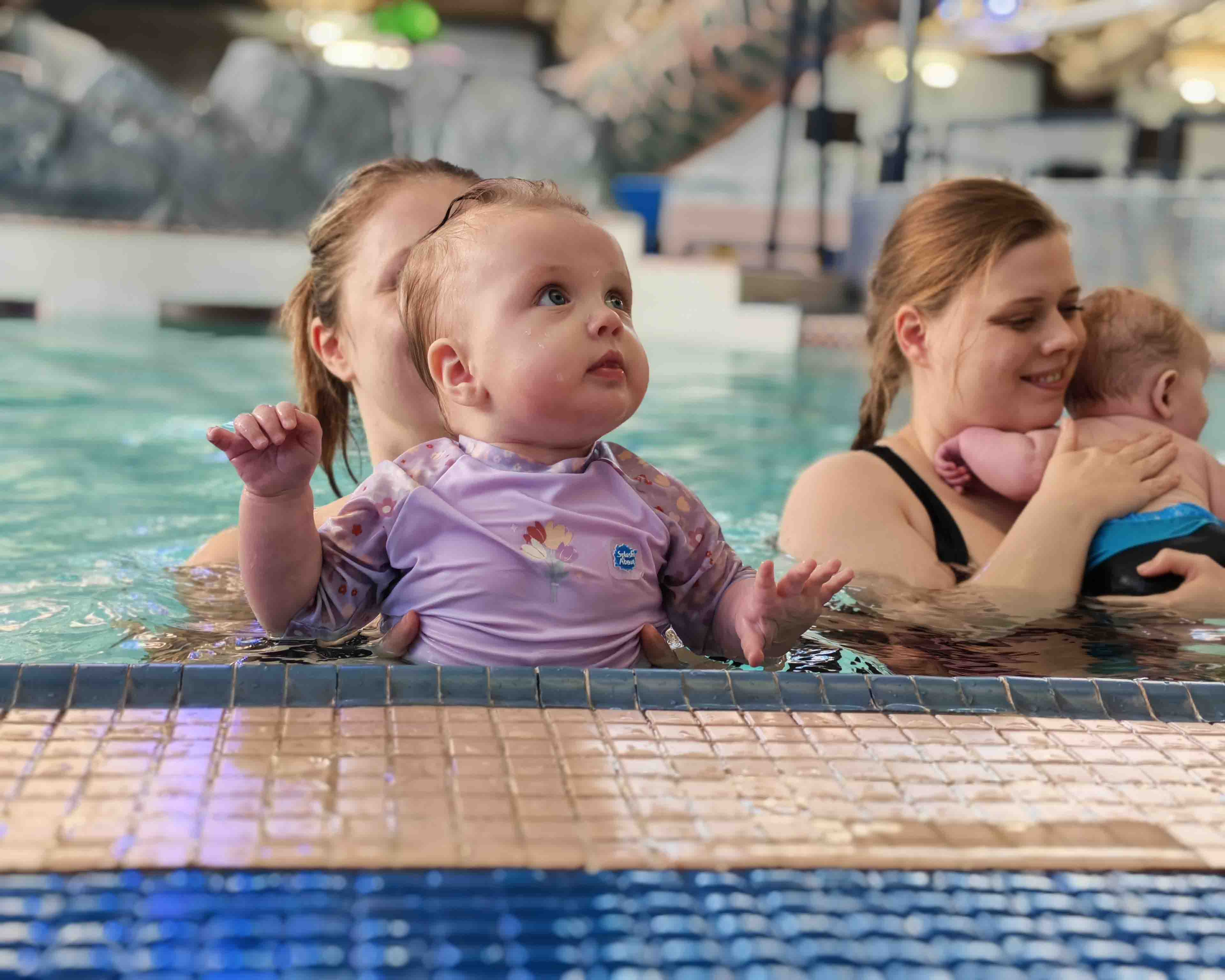 parent and child at the side of a swimming pool