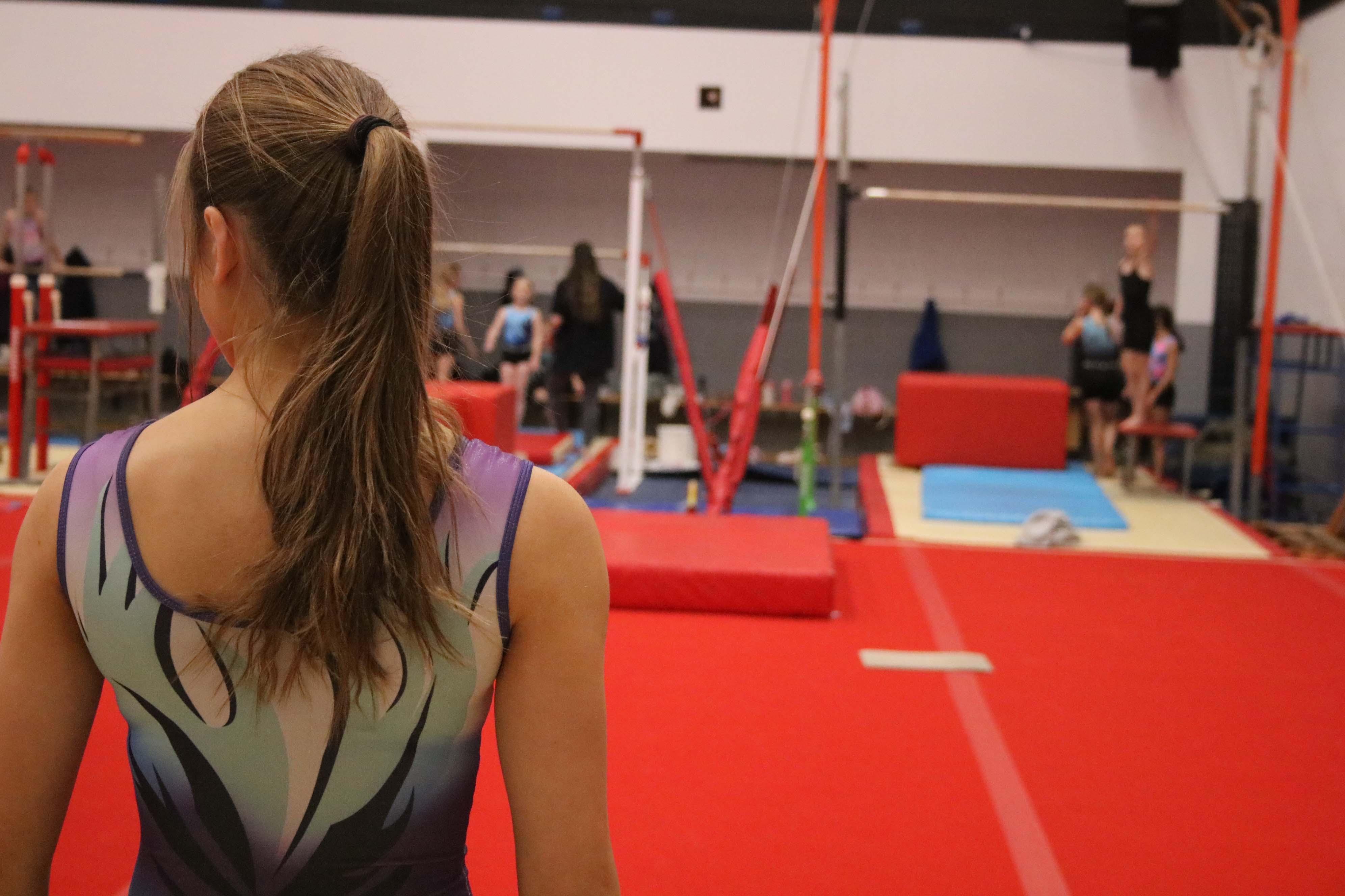 gymnastics - image of girl approaching gymnastics apparatus to train