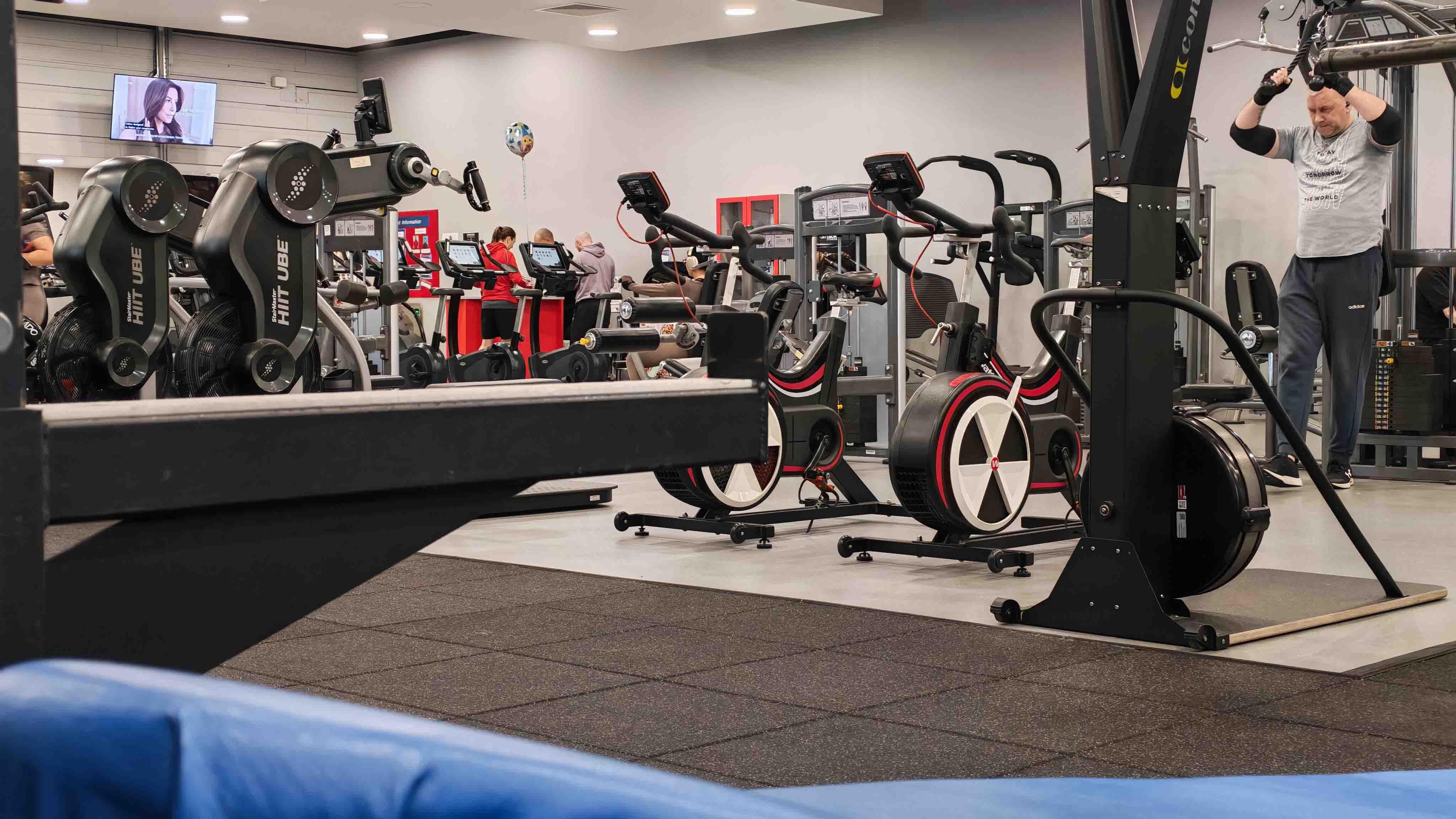 gym memberships - the inside of a gymnasium, with a man exercising