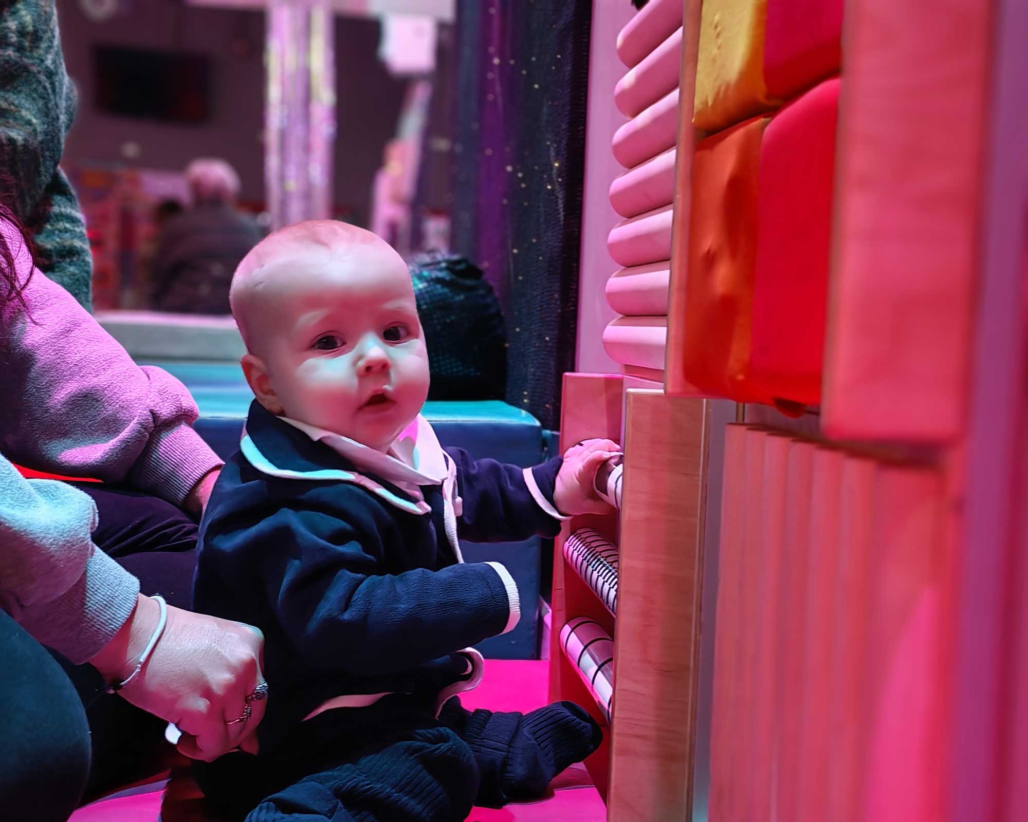baby smiling at warm lights in dimensions sensory room