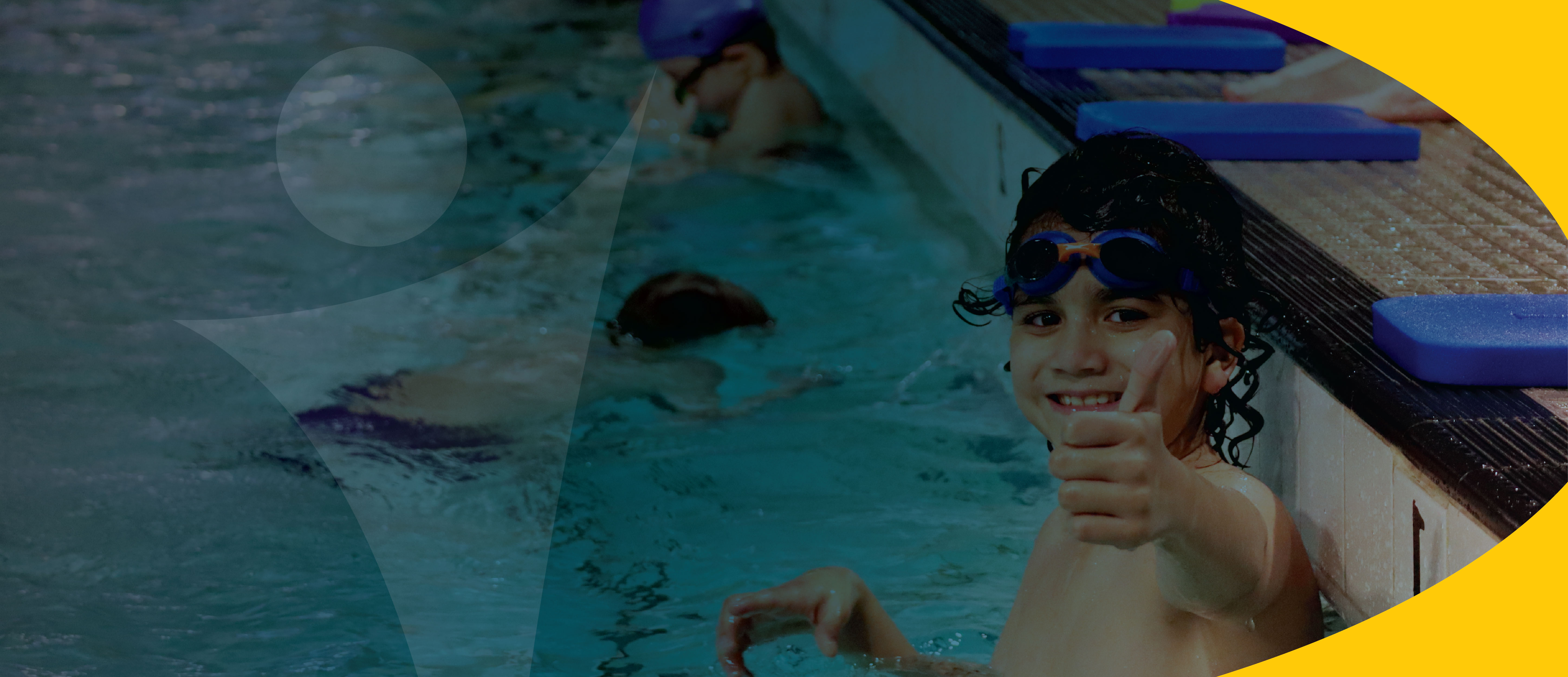 photo of young boy in swimming pool giving thumbs up